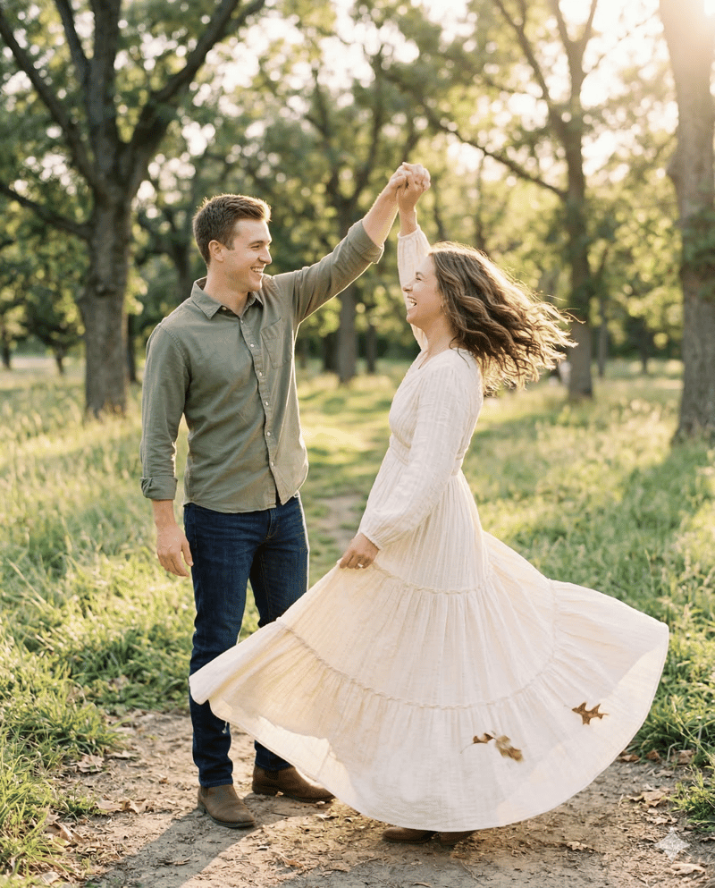 Couple twirling in playful engagement photo pose with flowing dress