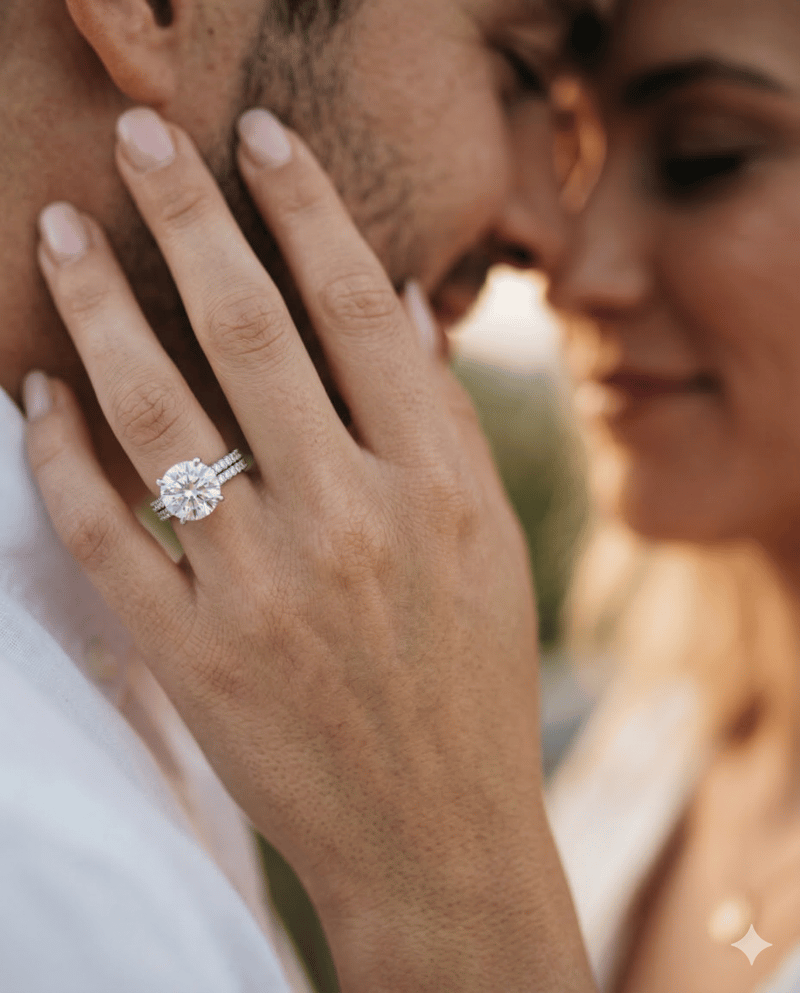 Engagement ring close-up pose with couple hugging in background